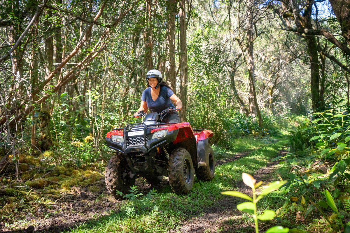 Woman riding through the jungle on an ATV