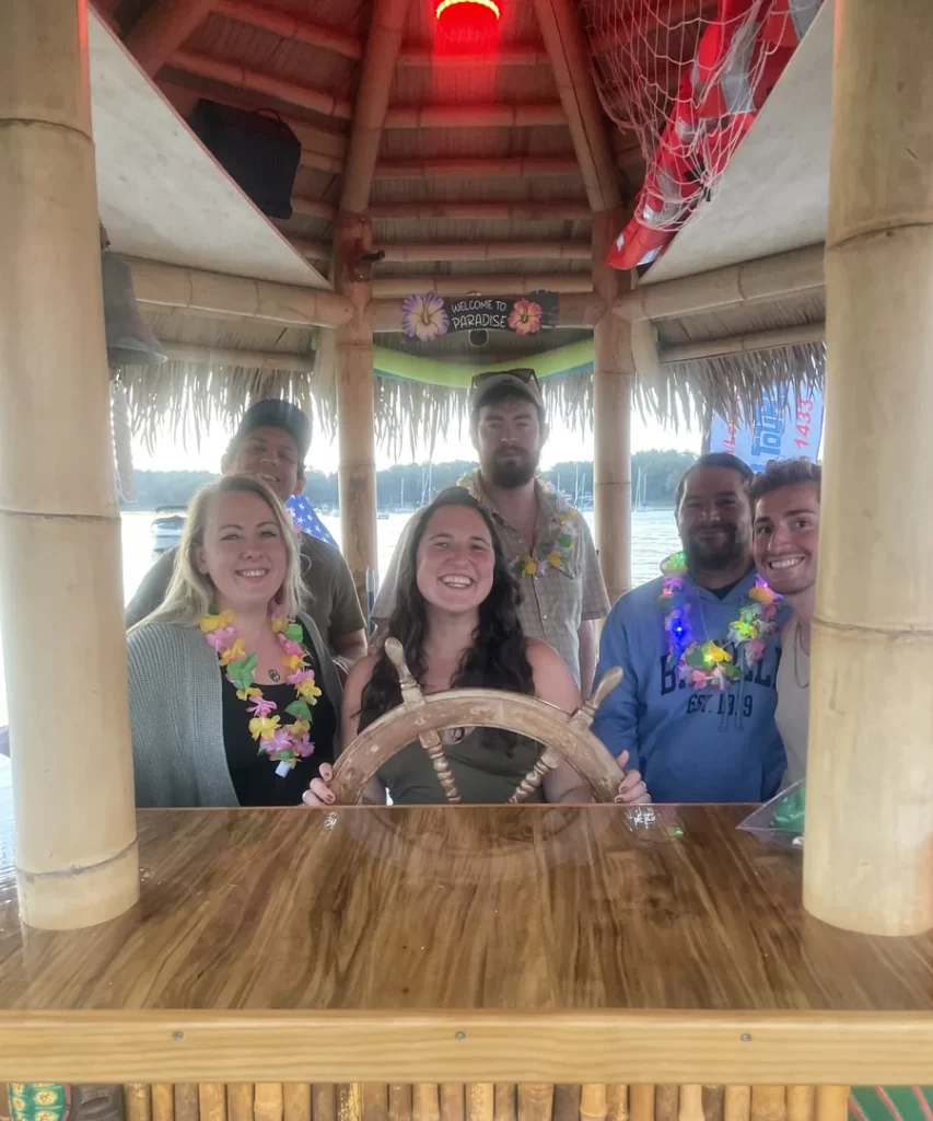 TOMIS team members behind the wheel of a client tiki boat